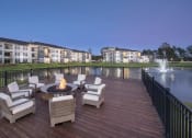 Thumbnail 6 of 33 - Firepit area on dock by lake in evening at The Parkway on Westlake, Humble, Texas