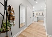 Thumbnail 69 of 124 - A hallway with a coat rack and mirrors on the wall