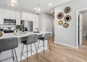 Thumbnail 70 of 124 - A kitchen with a white counter top and grey bar stools at Madison Prickett Preserve, Pennsylvania