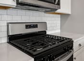 Thumbnail 108 of 124 - A modern kitchen with a stove top oven and microwave above it at Madison Prickett Preserve, Yardley, 19067