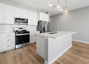 Thumbnail 99 of 124 - A kitchen with white cabinets and a wooden floor at Madison Prickett Preserve, Yardley