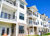 Thumbnail 113 of 124 - a row of apartments with balconies and a sidewalk at Madison Prickett Preserve, Yardley