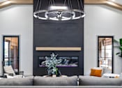 Thumbnail 8 of 124 - A modern living room with a grey sofa, a fireplace, and a hanging light fixture at Madison Prickett Preserve, Yardley Pennsylvania