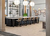 Thumbnail 9 of 124 - A modern kitchen with a black counter and wooden beams at Madison Prickett Preserve, Yardley