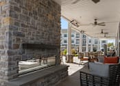 Thumbnail 57 of 124 - A patio with a stone fireplace and a ceiling fan at Madison Prickett Preserve, Pennsylvania