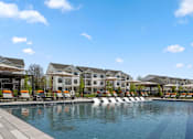 Thumbnail 45 of 124 - A large swimming pool with lounge chairs and a resort-style building in the background at Madison Prickett Preserve, Yardley, PA