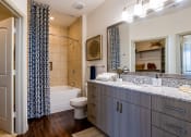 Thumbnail 16 of 33 - a bathroom with a sink and a toilet and a shower at The Parkway on Westlake, Humble, TX, 77346