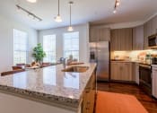 Thumbnail 12 of 33 - a kitchen with a granite counter top and a sink at The Parkway on Westlake, Humble, TX