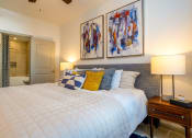 Thumbnail 15 of 33 - a bedroom with a bed and two paintings on the wall at The Parkway on Westlake, Humble