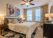 Thumbnail 14 of 33 - a bedroom with a bed and a ceiling fan at The Parkway on Westlake, Humble, Texas