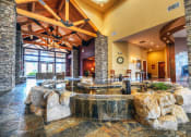 Thumbnail 17 of 30 - a large living room with a large rock fountain in the middle of the room at Madison Sierra Sun, Puyallup Washington