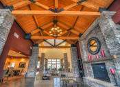 Thumbnail 16 of 30 - a large living room with a vaulted wood ceiling and stone walls at Madison Sierra Sun, Puyallup, WA
