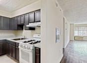 Thumbnail 16 of 16 - A kitchen with a white stove and black cabinets.