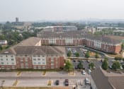 Thumbnail 16 of 17 - a large brick building with a parking lot in front of it and a city in the background
