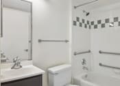 Thumbnail 10 of 16 - A white bathroom with a sink, toilet, and bathtub.