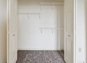 Thumbnail 6 of 26 - A white closet with two shelves and a grey carpet.