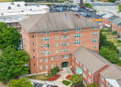 Thumbnail 2 of 17 - an aerial view of a brick building with trees and a parking lot