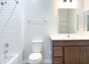 Thumbnail 12 of 18 - A white toilet sits next to a white sink in a bathroom.