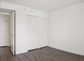 Thumbnail 9 of 16 - A room with a white door and two white closet doors.