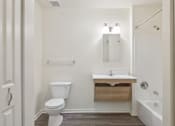 Thumbnail 25 of 26 - A white bathroom with a toilet, sink, and mirror.