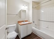 Thumbnail 7 of 26 - A white bathroom with a toilet, sink, and bathtub.