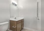 Thumbnail 11 of 25 - A white toilet sits next to a sink in a small bathroom.
