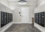 Thumbnail 17 of 23 - A hallway with a white door and black lockers on both sides.