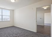 Thumbnail 23 of 26 - A room with a large window and a carpeted floor.