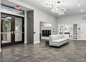 Thumbnail 19 of 23 - A white couch sits in a room with a grey floor and a white ceiling.