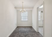 Thumbnail 10 of 17 - an empty living room with a chandelier and a window