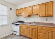 Thumbnail 11 of 17 - a kitchen with wooden cabinets and a stove and a sink