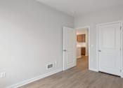 Thumbnail 2 of 25 - A room with two white doors and a wooden floor.