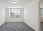 Thumbnail 22 of 26 - A room with a carpeted floor and a window.