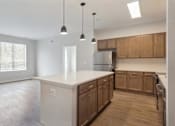 Thumbnail 1 of 25 - A kitchen with wooden cabinets and a white countertop.