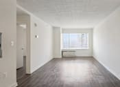 Thumbnail 13 of 16 - A large empty room with a window and a white couch.