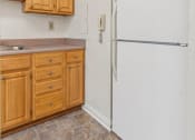 Thumbnail 12 of 17 - a kitchen with a white refrigerator and wooden cabinets