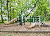Thumbnail 16 of 18 - A playground with a slide, swings, and a bench.