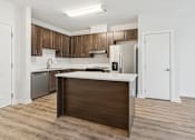 Thumbnail 22 of 23 - A kitchen with a white counter top and wooden cabinets.