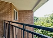 Thumbnail 31 of 75 - A balcony with a black railing and a brick wall.