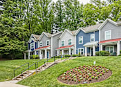 Thumbnail 2 of 18 - A row of houses with a flower bed in the front.