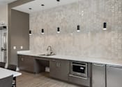 Thumbnail 13 of 23 - A modern kitchen with a tile backsplash and stainless steel appliances.