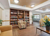 Thumbnail 7 of 17 - a seating area with couches and chairs and a bookshelf with books
