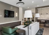 Thumbnail 11 of 23 - A modern living room with a flat screen TV mounted on the wall.