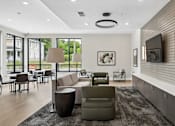 Thumbnail 10 of 23 - A modern living room with a grey sofa, a black coffee table, and a grey rug.