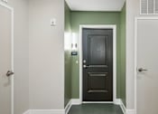 Thumbnail 14 of 23 - A hallway with a black door in the middle.