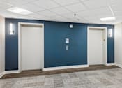 Thumbnail 46 of 75 - A long hallway with doors on both sides and a tiled floor.