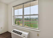 Thumbnail 16 of 26 - A room with a window overlooking a baseball field.