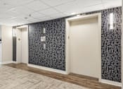 Thumbnail 29 of 75 - A hallway with a patterned wallpaper and a wooden floor.