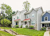 Thumbnail 8 of 18 - A row of houses with a green lawn in front.