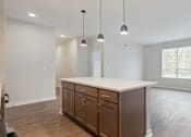 Thumbnail 9 of 25 - A kitchen with wooden cabinets and a white countertop.